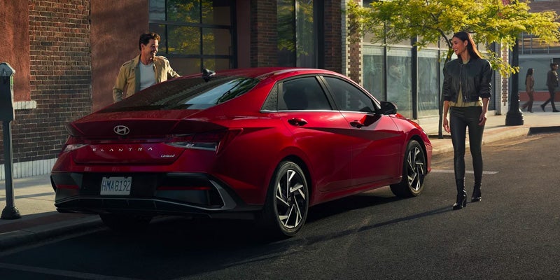 Hyundai Elantra parked roadside with people nearby