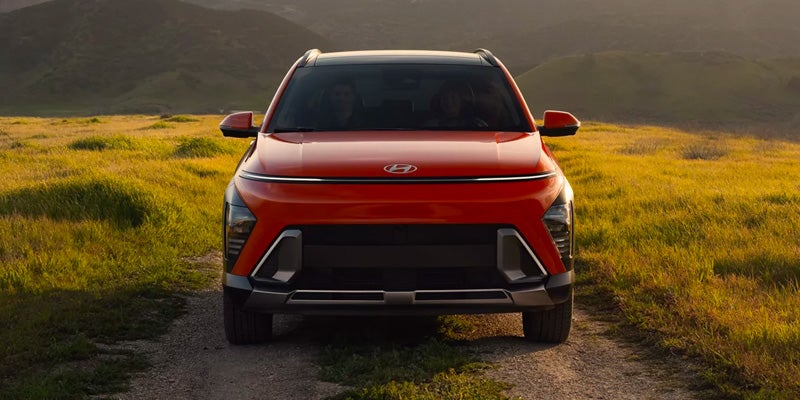 Red Hyundai Kona parked with mountain backdrop