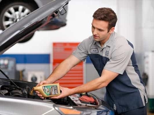 Bentley Hyundai in Huntsville AL technician adding oil to engine